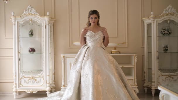 Mujer en vestido largo posa caminando junto a la habitación con muebles — Vídeos de Stock