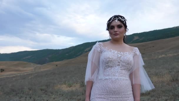 Mujer con diadema en la cabeza posa contra el paisaje montañoso — Vídeo de stock