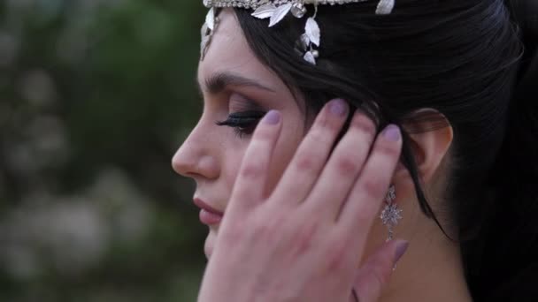 Dame met heldere make-up en oorbellen poses fixeren haar krullen — Stockvideo