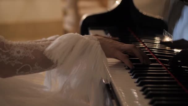 Mujer elegante en vestido blanco toca el piano en primer plano hall — Vídeos de Stock