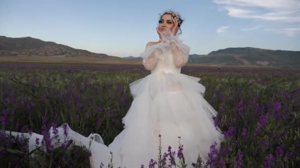 Vrouw in bruiloft bouffant rok op veld door heuvel slow motion — Stockvideo