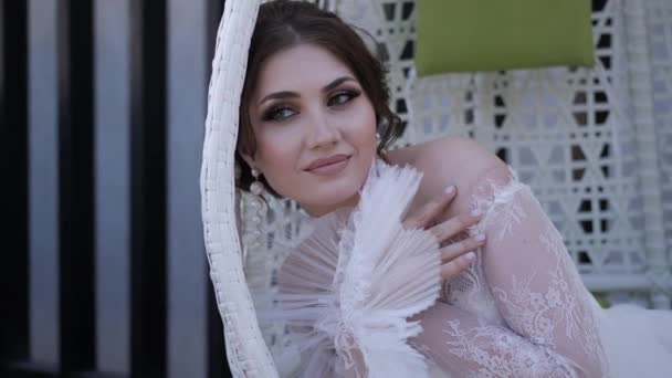Glückliche Braut im stylischen Brautkleid ruht im Hängesessel — Stockvideo