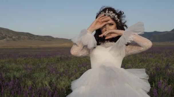 Брюнетка леди в свадебном платье со шнурками позирует в цветах — стоковое видео