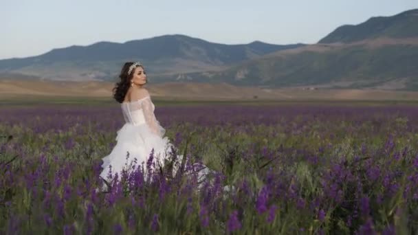 Glückliche Braut in stilvollem Kleid posiert zwischen schönen Blumen — Stockvideo