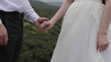 Romantik düğün çifti, titreyen elleri ağır çekimde birleştirir.