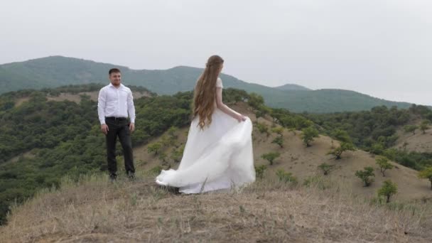 Dame souriante en robe de mariée blanche longue danse sur prairie — Video