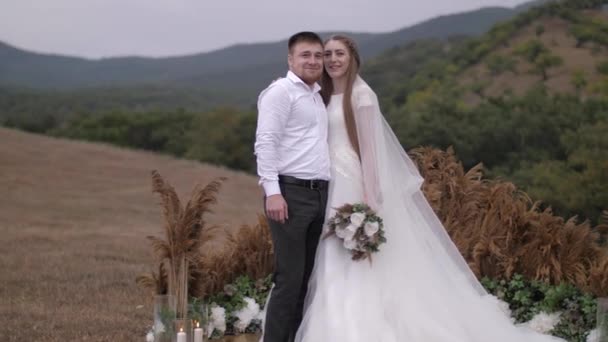 Прекрасная свадебная пара обнимает стоя возле украшений — стоковое видео