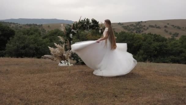Hermosa novia con el pelo largo y suelto ondeado por remolinos de viento — Vídeos de Stock