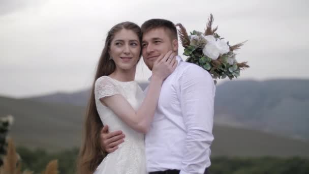 Ung kvinna i vit bröllopsklänning löper hand på fästman ansikte — Stockvideo