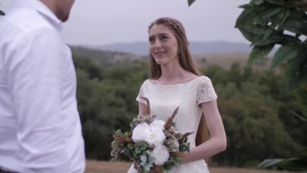 Νεαρή γυναίκα χαμογελά κοιτάζοντας αρραβωνιαστικός στην τελετή του γάμου — Αρχείο Βίντεο