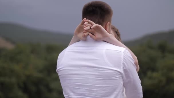 Bruid handen knuffelen gespierde verloofde tegen bosbouw heuvels — Stockvideo