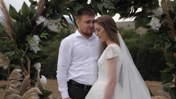 Romantic groom hugs bride in long white dress with veil — 图库视频影像