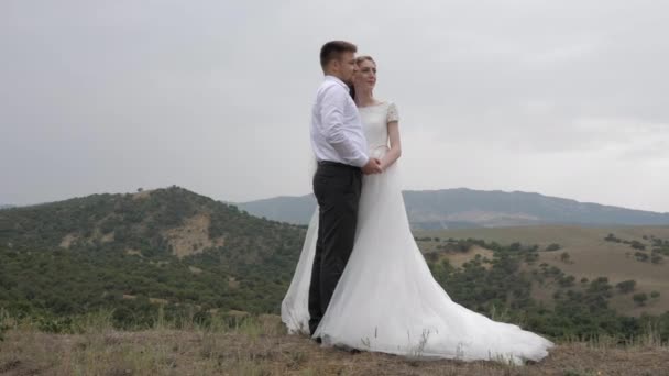 Knappe verloofde knuffels elegante bruid in lange trouwjurk — Stockvideo