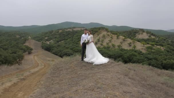 Tunangan yang tampan memeluk pengantin cantik dengan karangan bunga — Stok Video