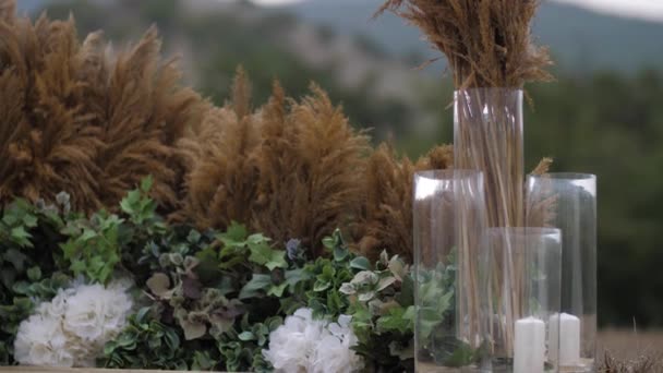 Décorations de fleurs près de grandes plumes brunes et des bougies — Video