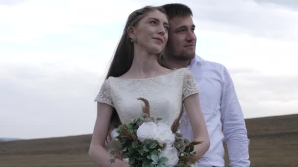Úžasný pár v lásce objetí a úsměvy na svatební den — Stock video