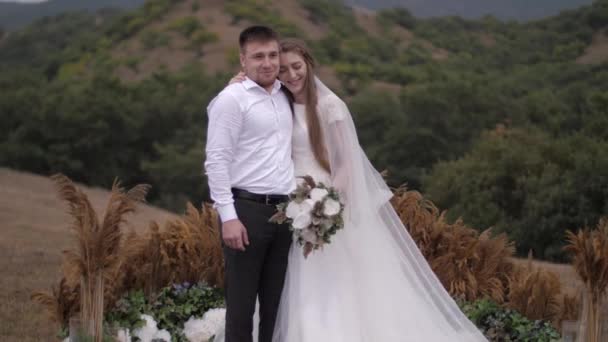 Bruid lacht en verbergt glimlach achter gekleurde bloem boeket — Stockvideo