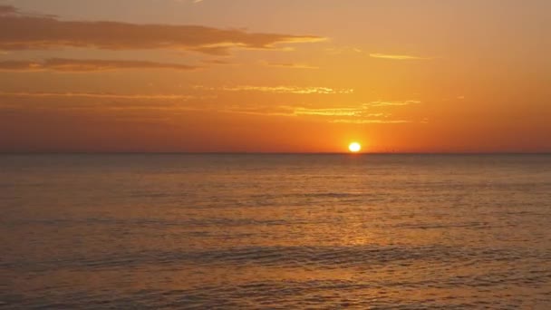 Harika okyanus turuncu güneş ışığını yansıtır gökyüzünün altında — Stok video