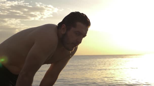Μυώδης τύπος στέκεται σε απέραντο ήρεμο νερό του ωκεανού αργή — Αρχείο Βίντεο