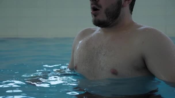 Stilig skäggig kille tar djupa andetag och dyker i vatten — Stockvideo