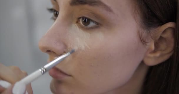 Professional makeup artists with manicure aligns concealer — Stock Video