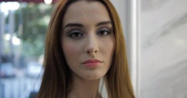 Yeni saç stili ve makyajlı model aynaya yakından bakıyor.