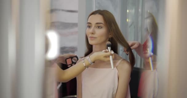 Los trabajadores del salón de belleza hacen el maquillaje y el peinado de señora bonita — Vídeos de Stock