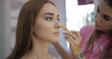 Güzellik salonu çalışanı model yüzüne fırçayla allık sürüyor