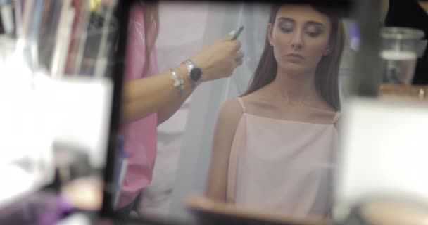 Trabajador de salón de belleza toma delineador de ojos que se refleja en el espejo — Vídeo de stock