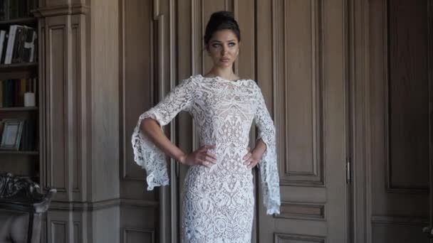 Lady in white lacy wedding dress stands near brown door — Stock videók