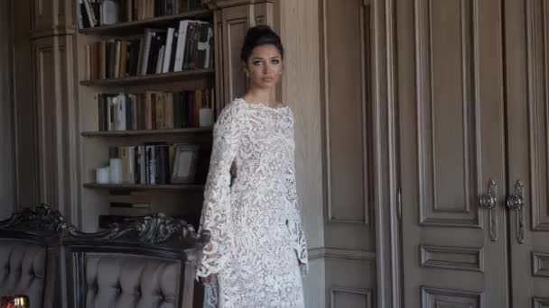 Professional model in long lacy dress walks along room — Stock videók