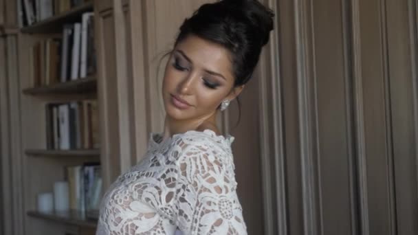 Pretty brunette in designed lacy wedding dress and earrings — Stockvideo