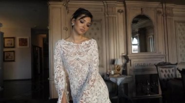 beautiful lady in long lacy tight wedding dress poses