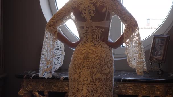 Donna in pizzo bianco abito da sposa stretto tiene le mani sui fianchi — Video Stock