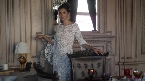 Элегантная леди в длинном кружевном свадебном платье прогуливается по комнате — стоковое видео
