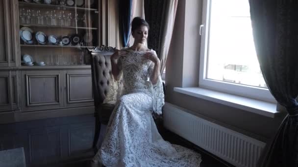 Елегантна брюнетка у весільній сукні біжить руками на плечах — стокове відео