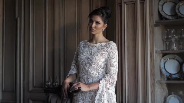 Attractive lady in long white lacy dress poses for camera — Stock videók