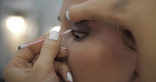 Visagiste yakın plan göz farı temizleyicisi kaşlarını temizliyor. — Stok video