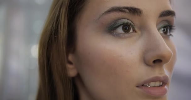 Mujer joven con ojos marrones parpadea después de dibujar flechas — Vídeos de Stock