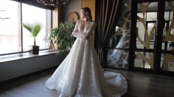 Elegant lady in long wedding dress poses for camera — Stok video