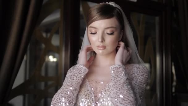 Красивая невеста в платье смотрит вокруг и фиксирует прическу — стоковое видео