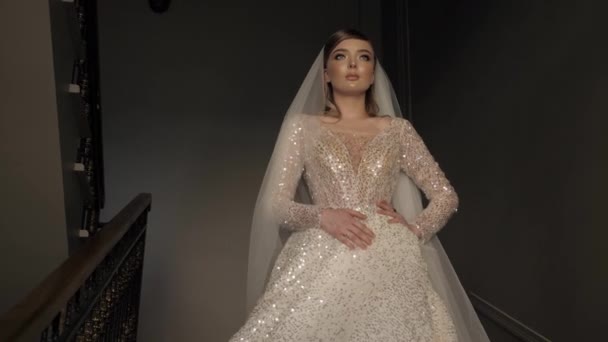 Lady in long wedding dress with shining diamonds poses — Stockvideo