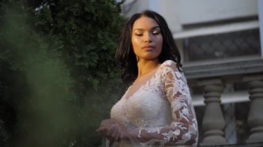 Gün batımında uzun kollu şık gelinlik içinde gelin.