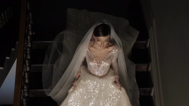 Krásná mladá žena ve svatebních šatech s dlouhým závojem zavřít — Stock video