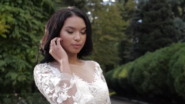 Chica atractiva en vestido de novia precioso en el parque verde — Vídeos de Stock