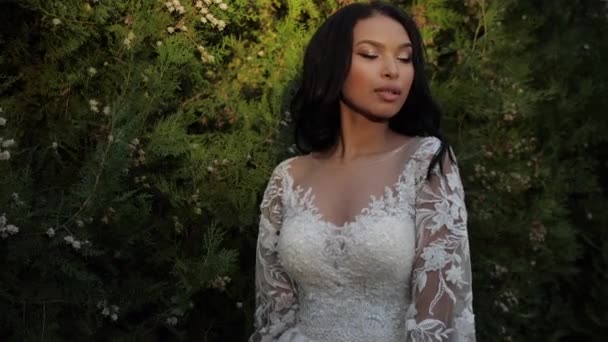 身穿漂亮婚纱的非洲裔美国女士在灌木丛边 — 图库视频影像