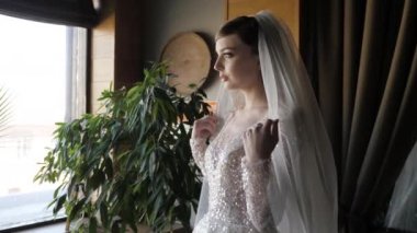 lady in wedding dress with long veil breathes deeply closeup