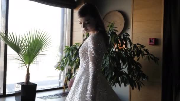 Beautiful bride fixes wedding dress with Swarovski crystals — Stock video