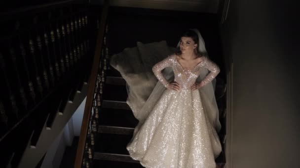 Пані в довгій весільній сукні з блискучими кристалами позує — стокове відео