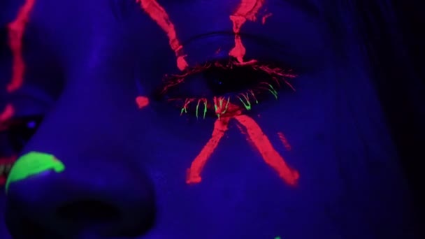 Fashionable lady with coloured neon farbs on face macro — Stok video